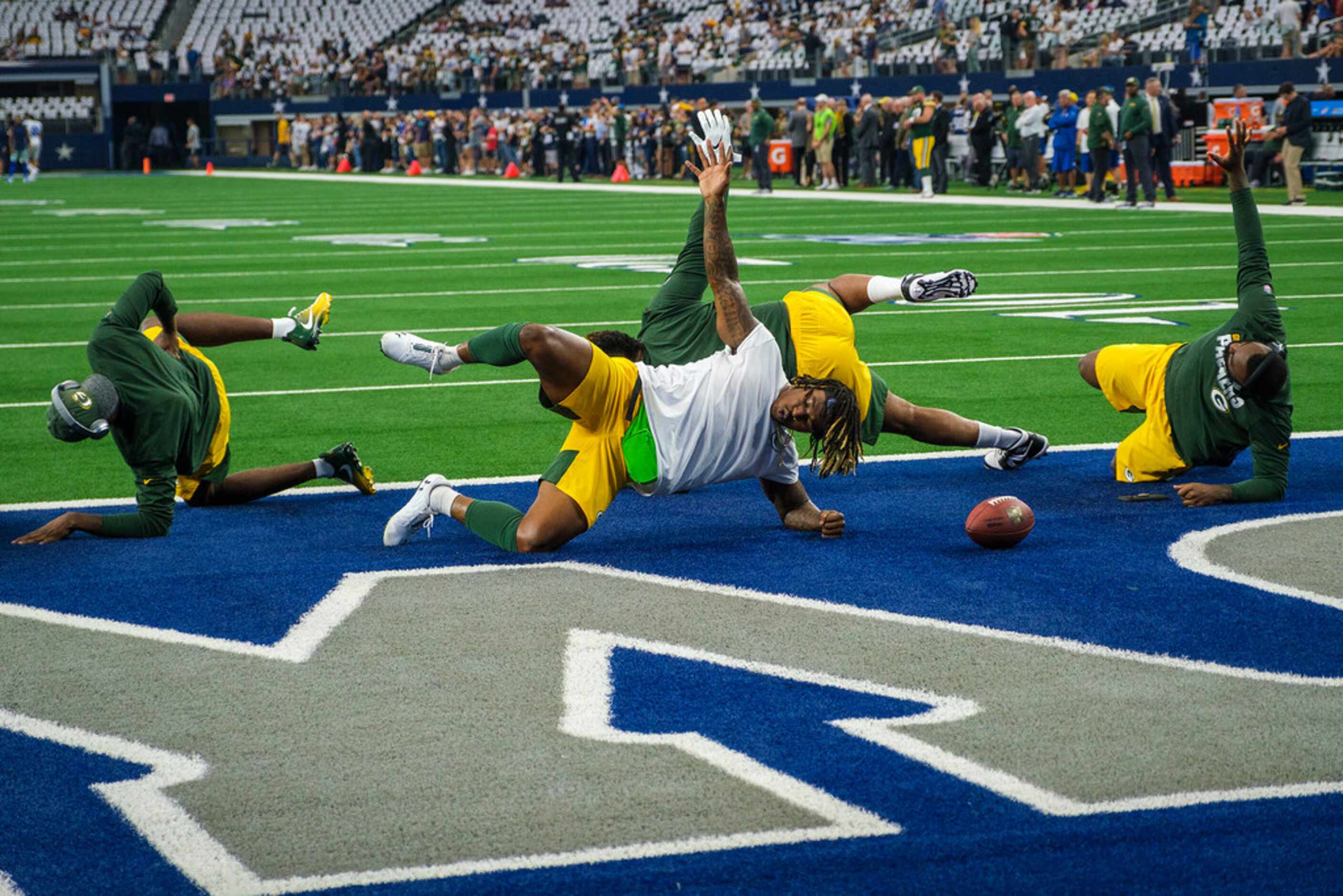 Green Bay Packers players warm up before an NFL football game against the Dallas Cowboys at...