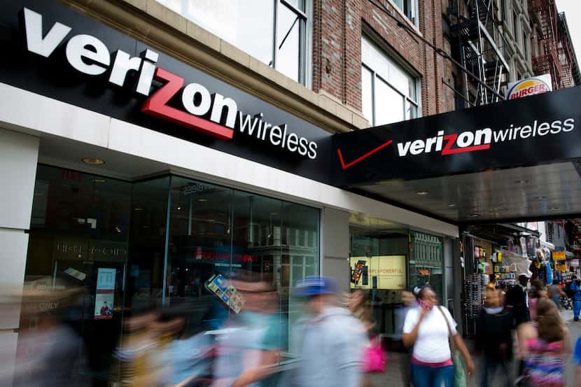 In this file photo, pedestrians pass a Verizon Wireless store on Canal Street in New York.