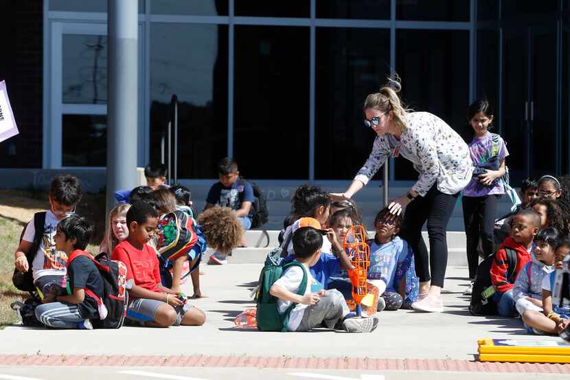 Second-grade teacher Stephanie Shannon helps students line up before being picked up from...