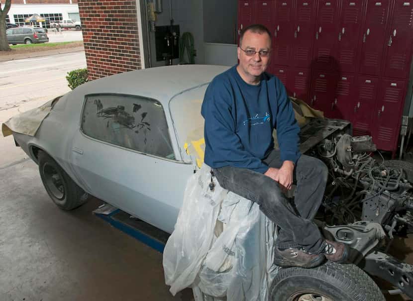 
MISD automotive technology instructor Monti Turner sits on a 1979 Chevy Camaro that...