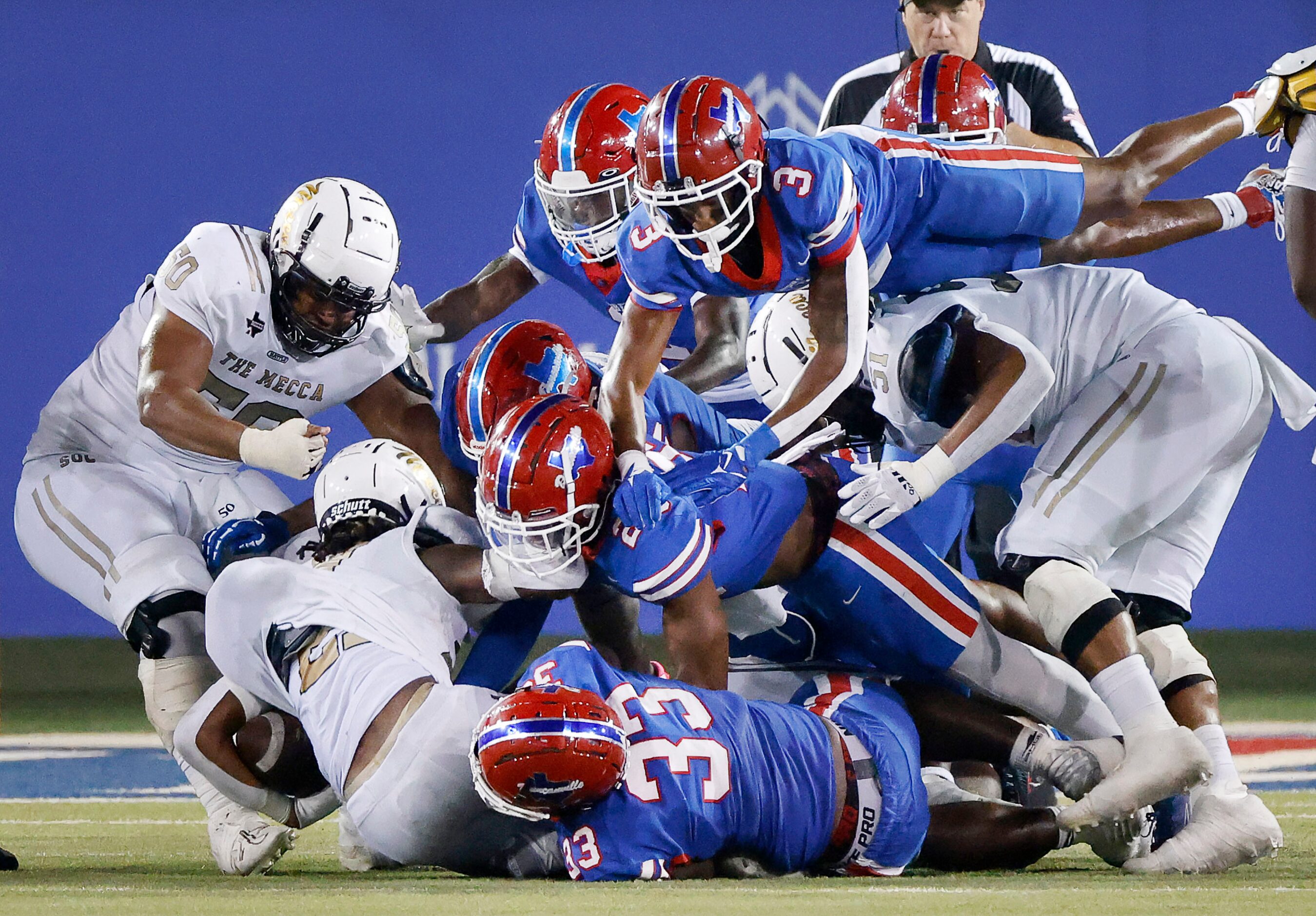 The Duncanville defense smothers South Oak Cliff running back Danny Green (21) during a...