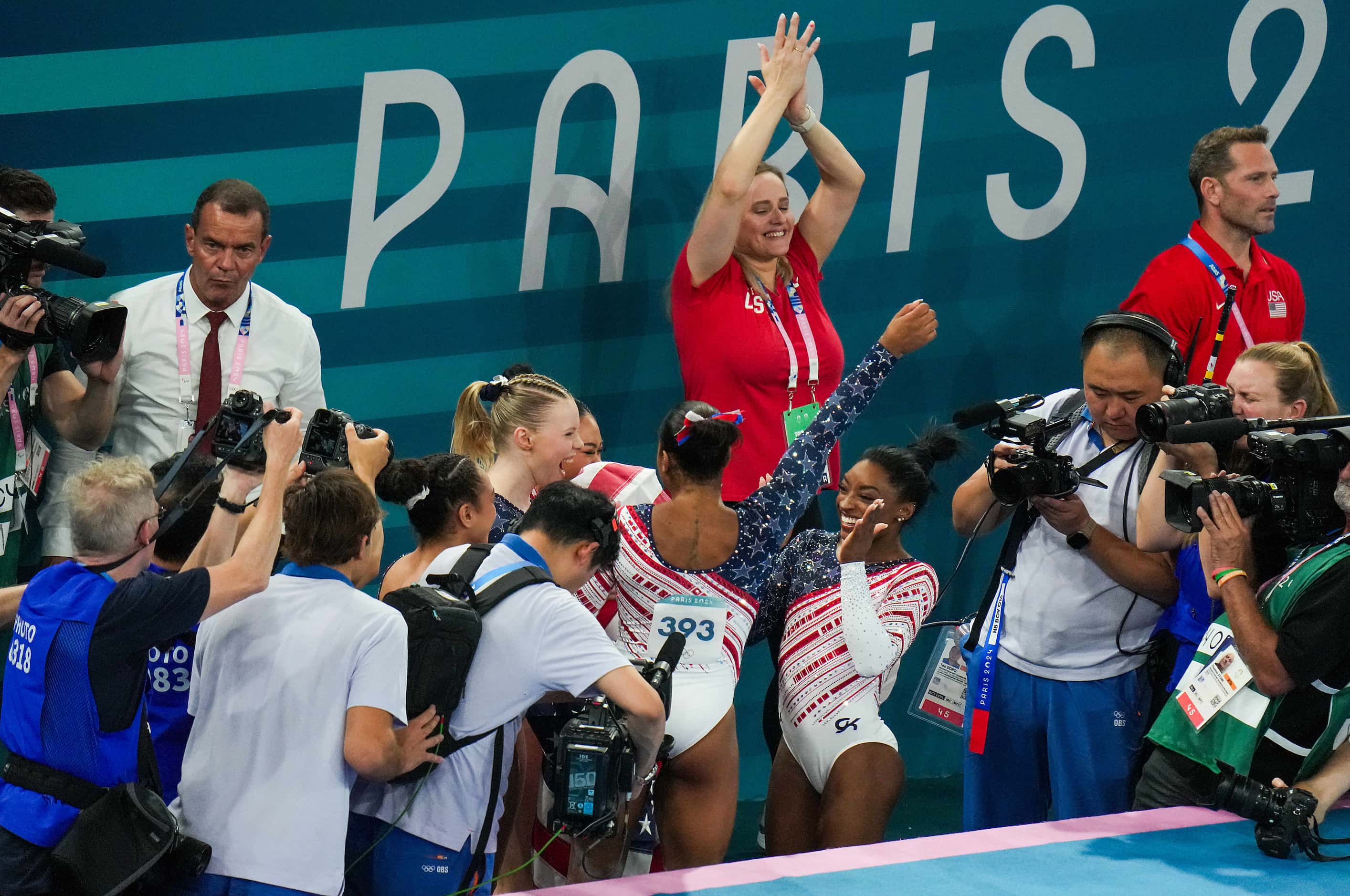 Simone Biles of the United States is surrounded by cameras as she celebrates with her...