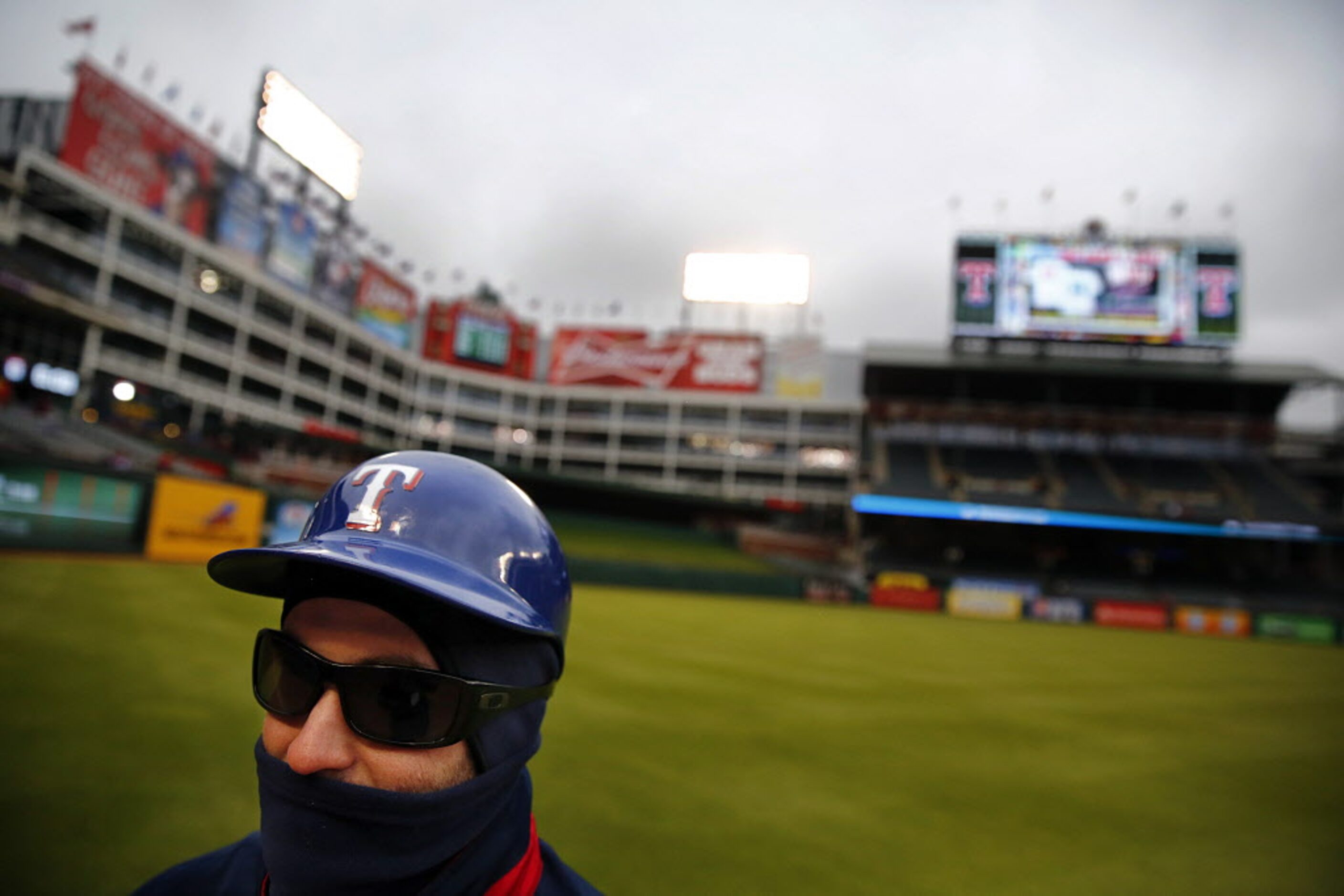 Texas Rangers field security man Matt Penn was bundled up against the chill as he guarded...