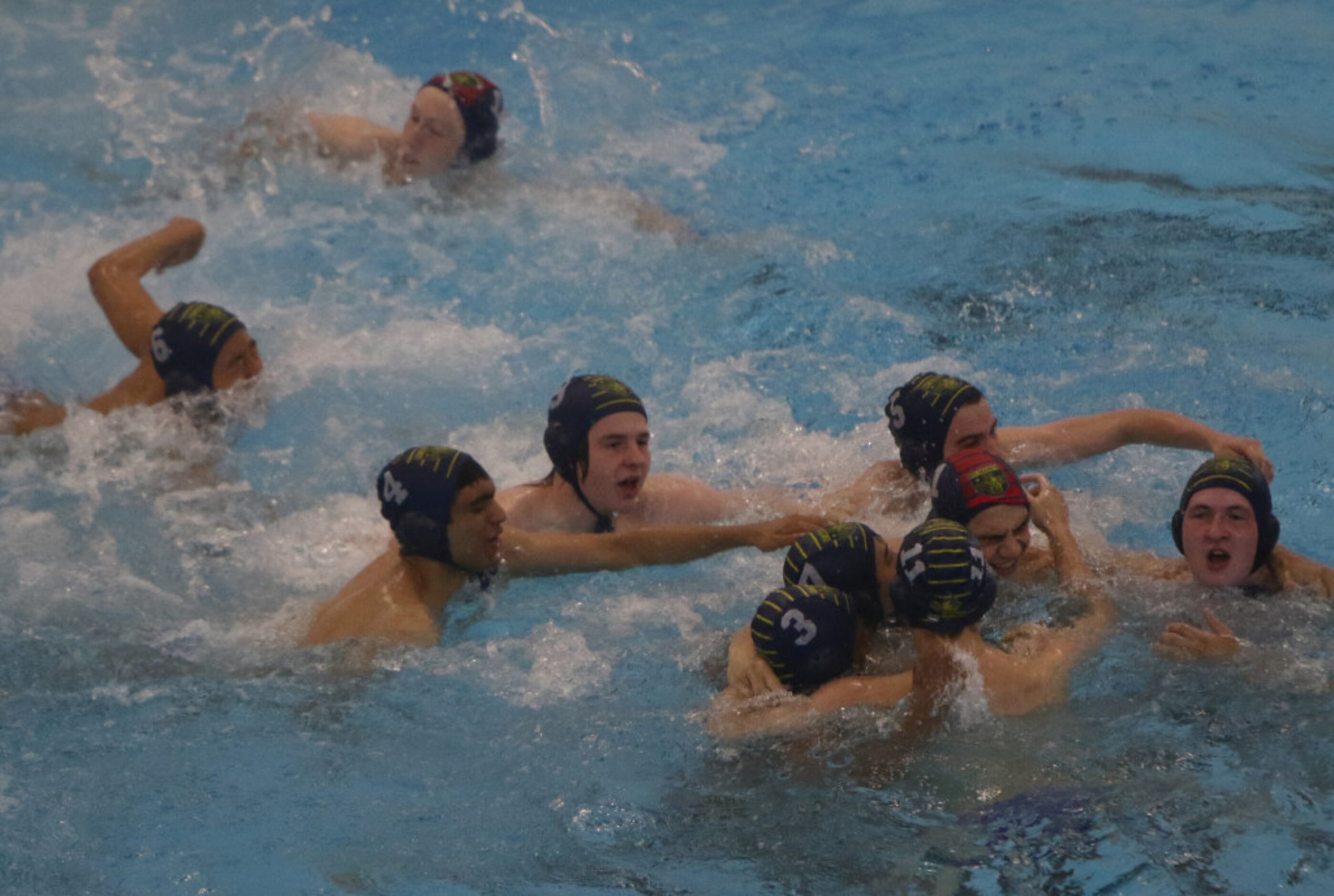 Members of the St Mark's water polo team celebrate their 7-6 victory over Flower Mound to...