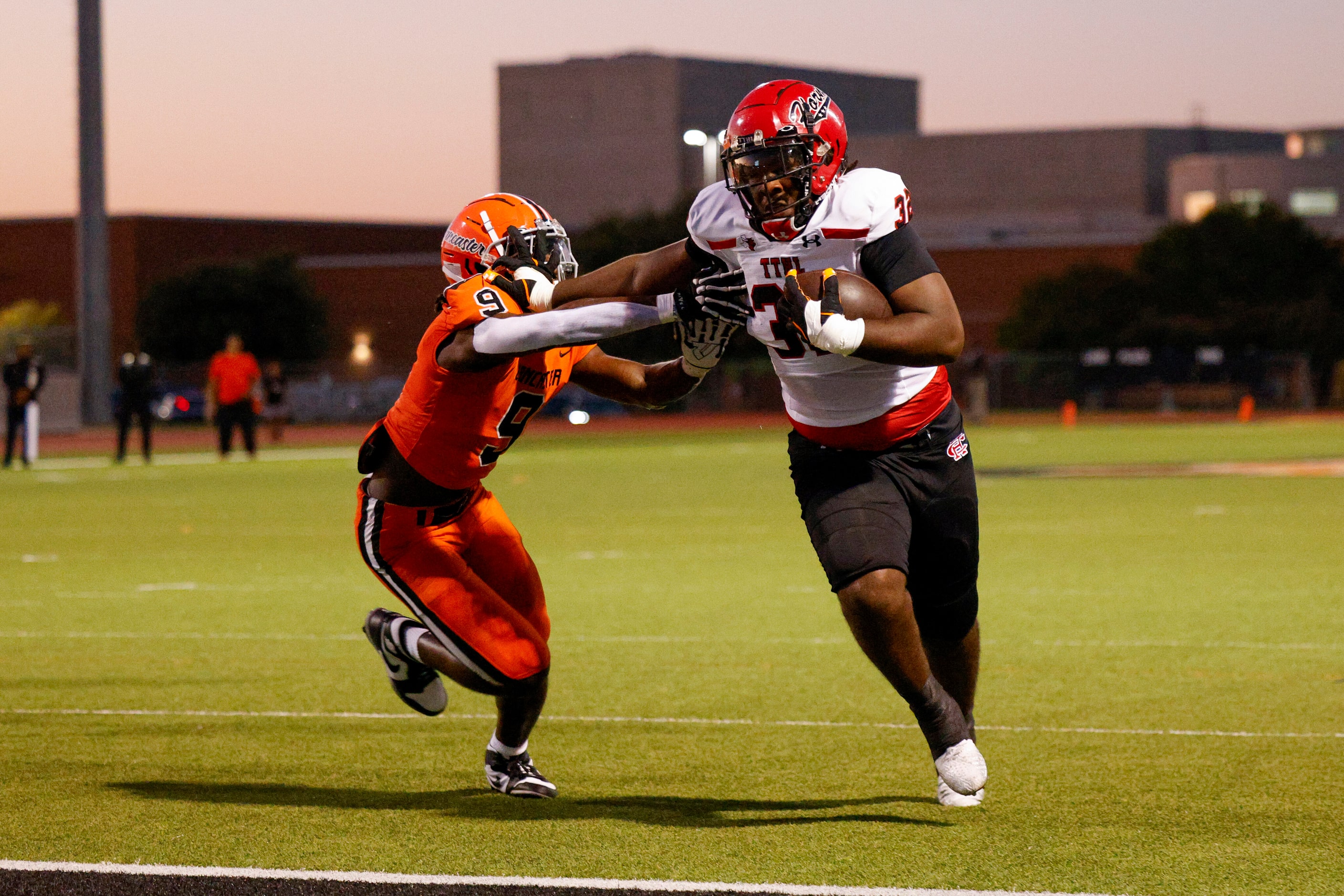 Cedar Hill running back Jalen Brewster (32) stiff arms Lancaster linebacker Dylan Sandles...