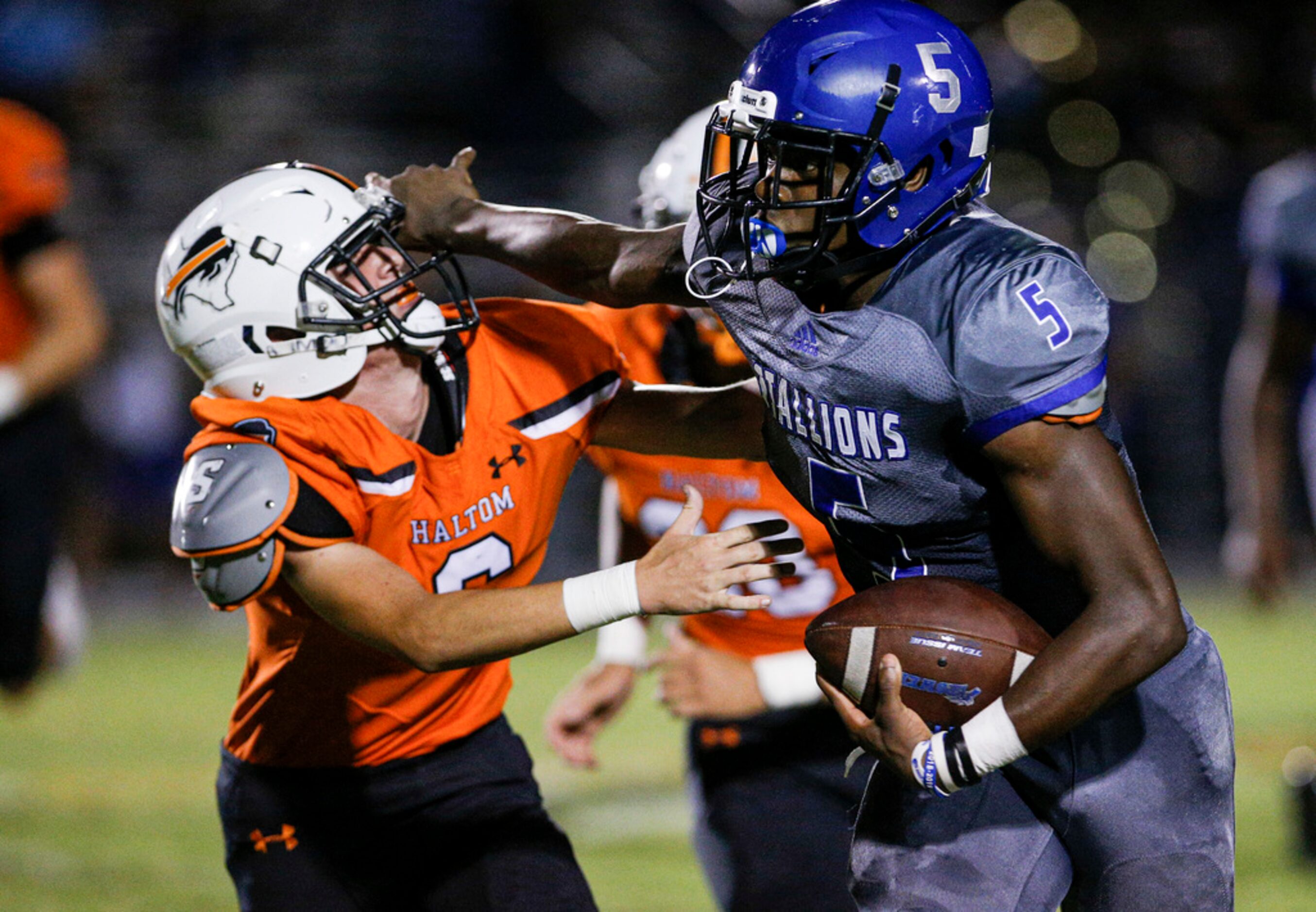 TXHSFB North Mesquite senior quarterback Kamaury Thompson (5), right, battles Haltom City...