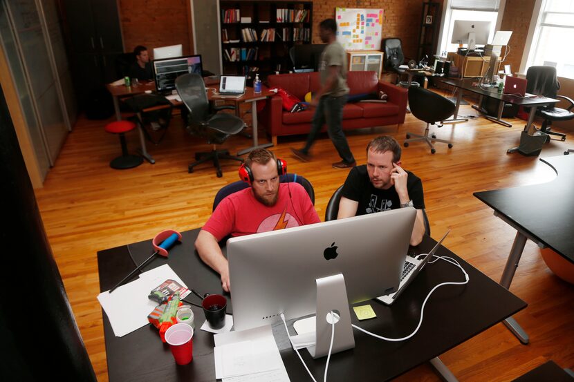 Brainspace developers Josh Longbrake, left, and Kevin Whitaker, right, look over code at...