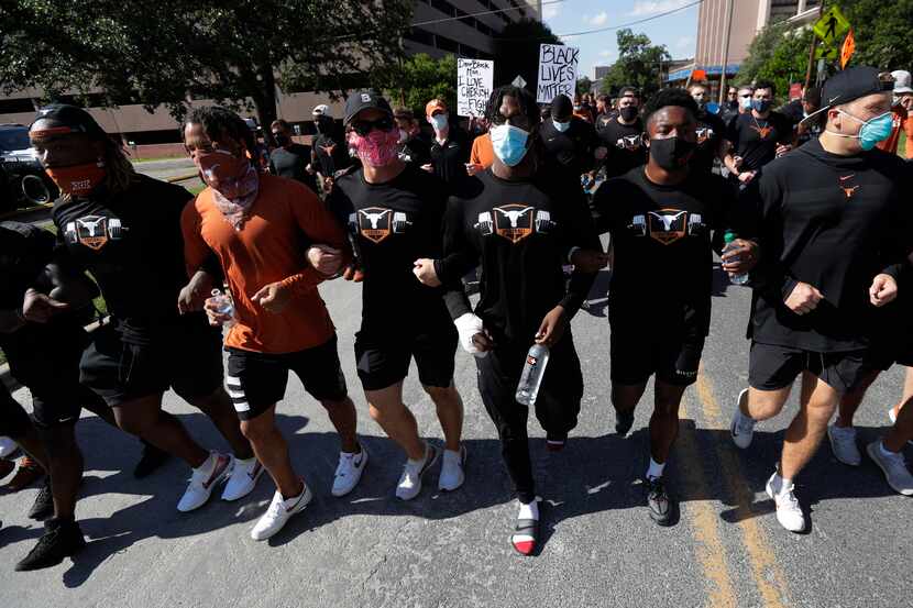 Members of the Austin police department march with members of the University of Texas...