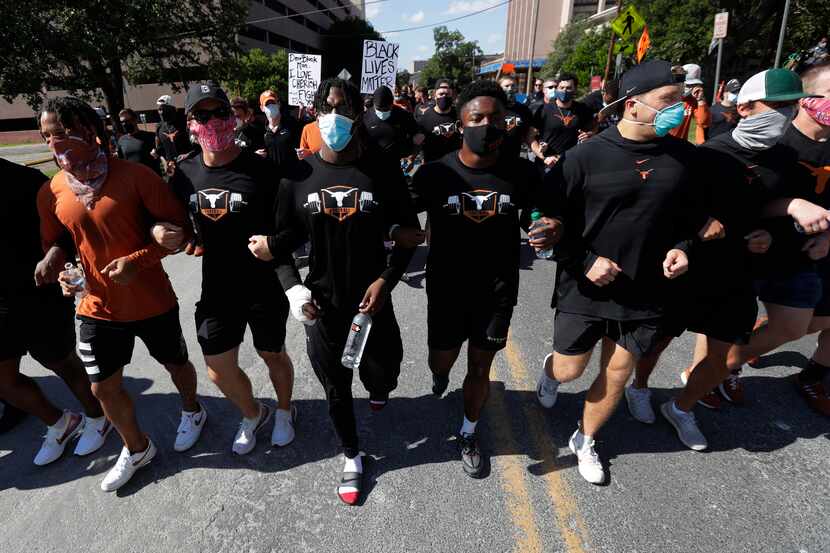 Members of the Austin police department march with members of the University of Texas...