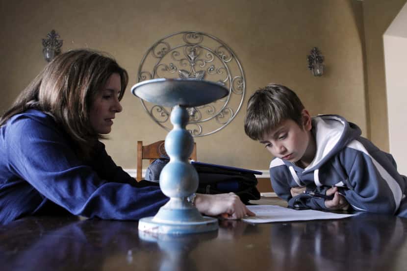 Maeve Siano helps her daughter, Delaney Siano, 8, with her homework at their home in Celina....