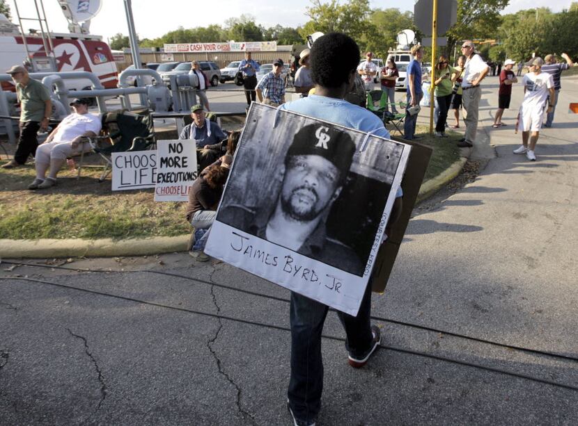A man wore a placard with James Byrd Jr.'s photo outside the Texas Department of Criminal...