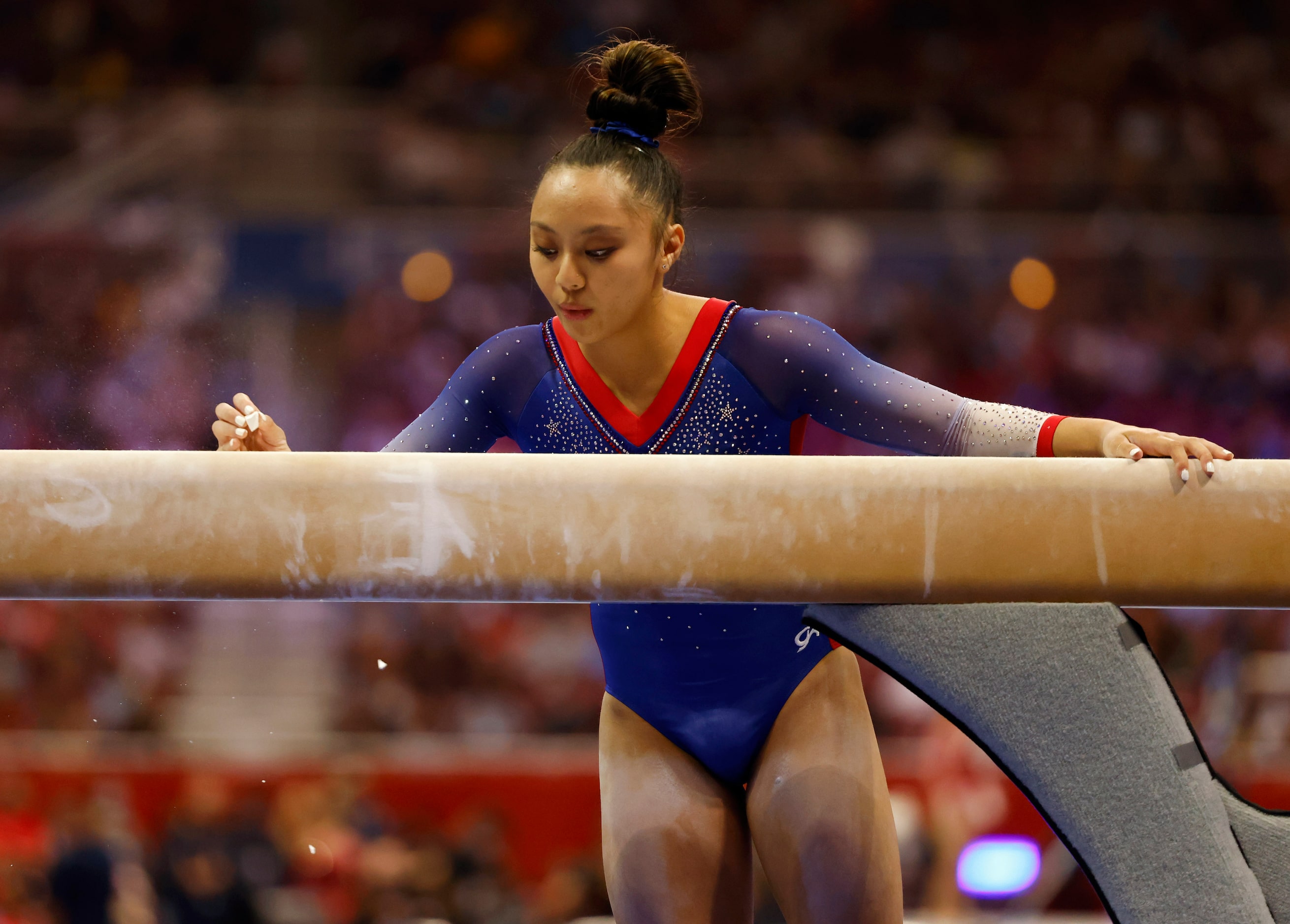 Emma Malabuyo of Texas Dreams marks her spot on the balance beam with chalk before competing...