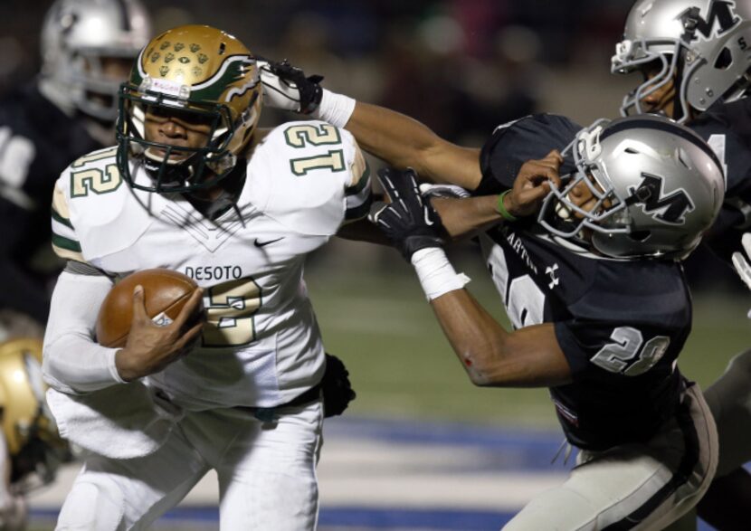 DeSoto High QB Desmon White (12) fights for a first down, as Arlington Martin High defender...