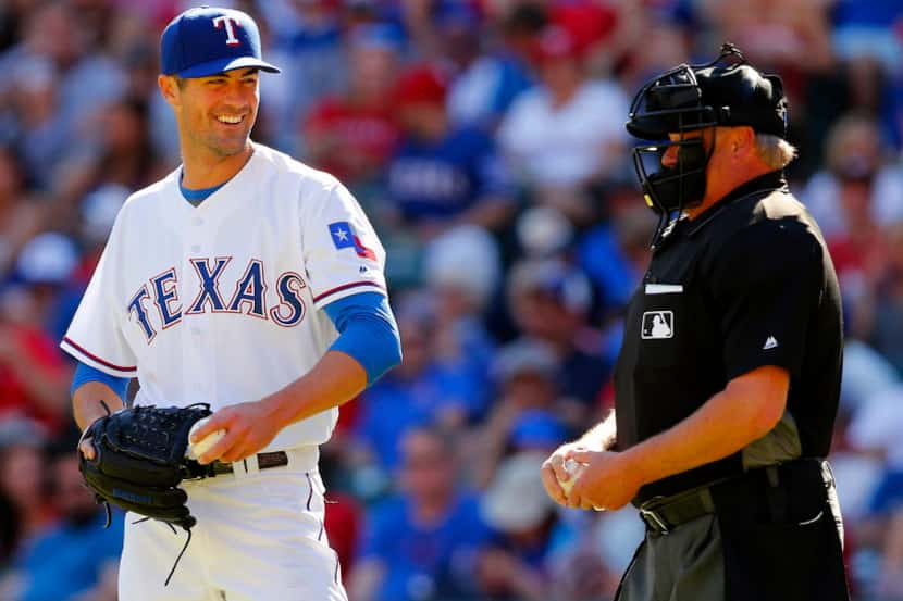 Texas Rangers starting pitcher Cole Hamels (35) laughs at  home plate umpire Jim Joyce after...
