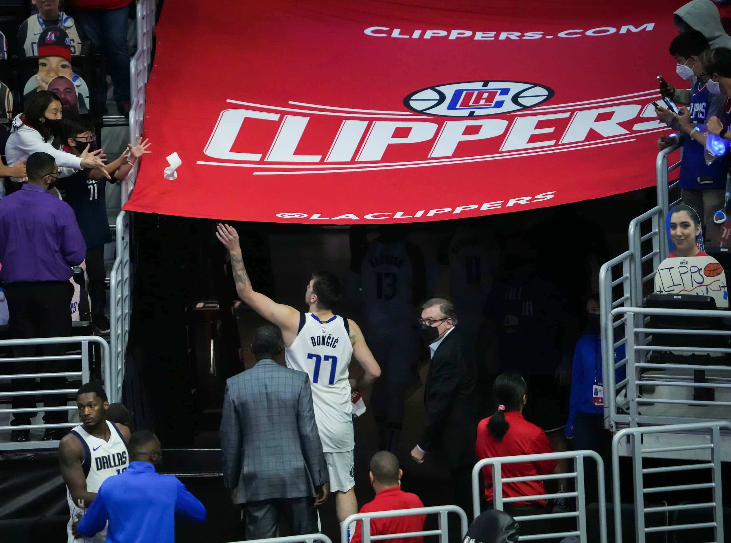Dallas Mavericks guard Luka Doncic tosses a sweatband to the crowd as he leaves the court...