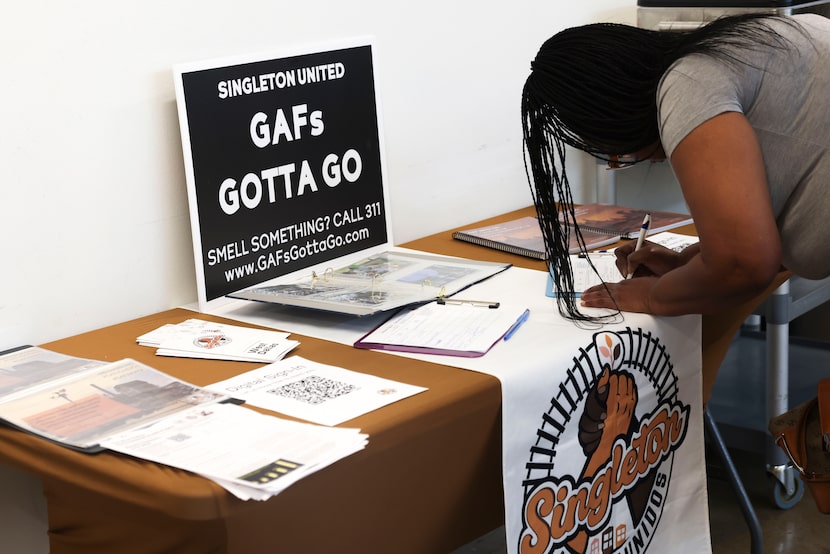 Residents sign up past a sign during a community meeting to learn the results of a public...