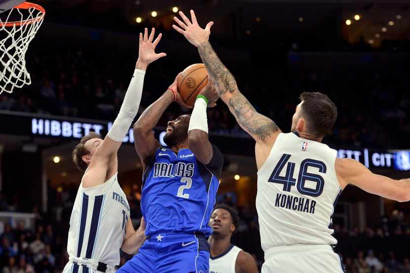 Dallas Mavericks guard Kyrie Irving (2) shoots between Memphis Grizzlies guards Luke...