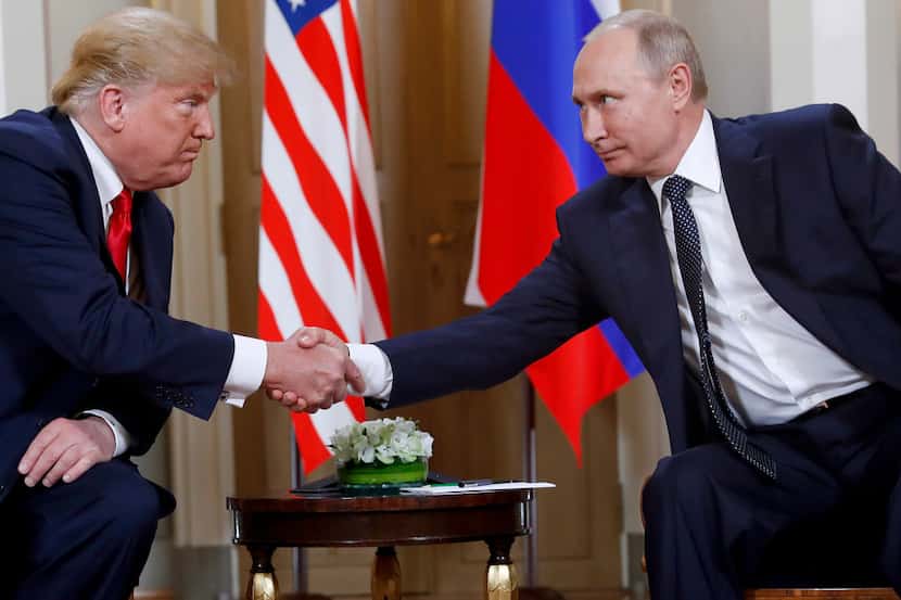 U.S. President Donald Trump and Russian President Vladimir Putin shake hands at the...