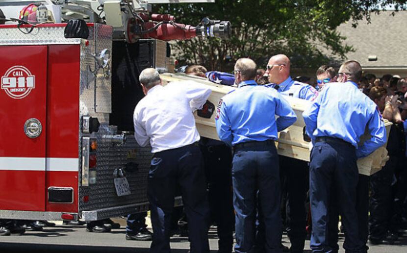 Brownwood firefighters load the casket of Lt. Shannon Stone onto a fire truck following...