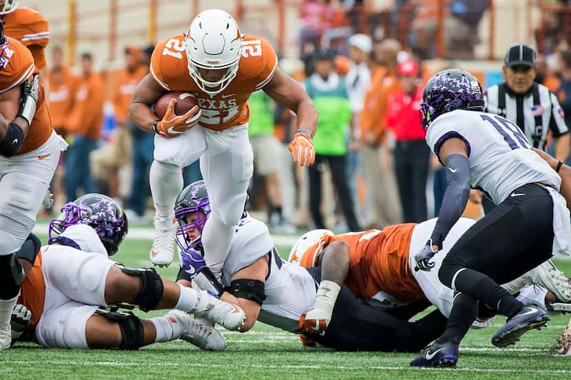 Texas running back Kyle Porter (21) is tripped up by the TCU defense during the first half...