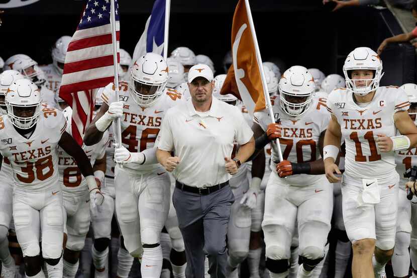 Texas head coach Tom Herman, center, takes the field with his team before the Longhorns'...