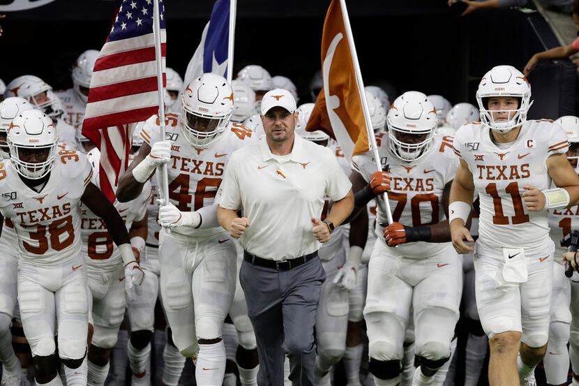 Texas head coach Tom Herman, center, takes the field with his team before Texas' 48-13 win...