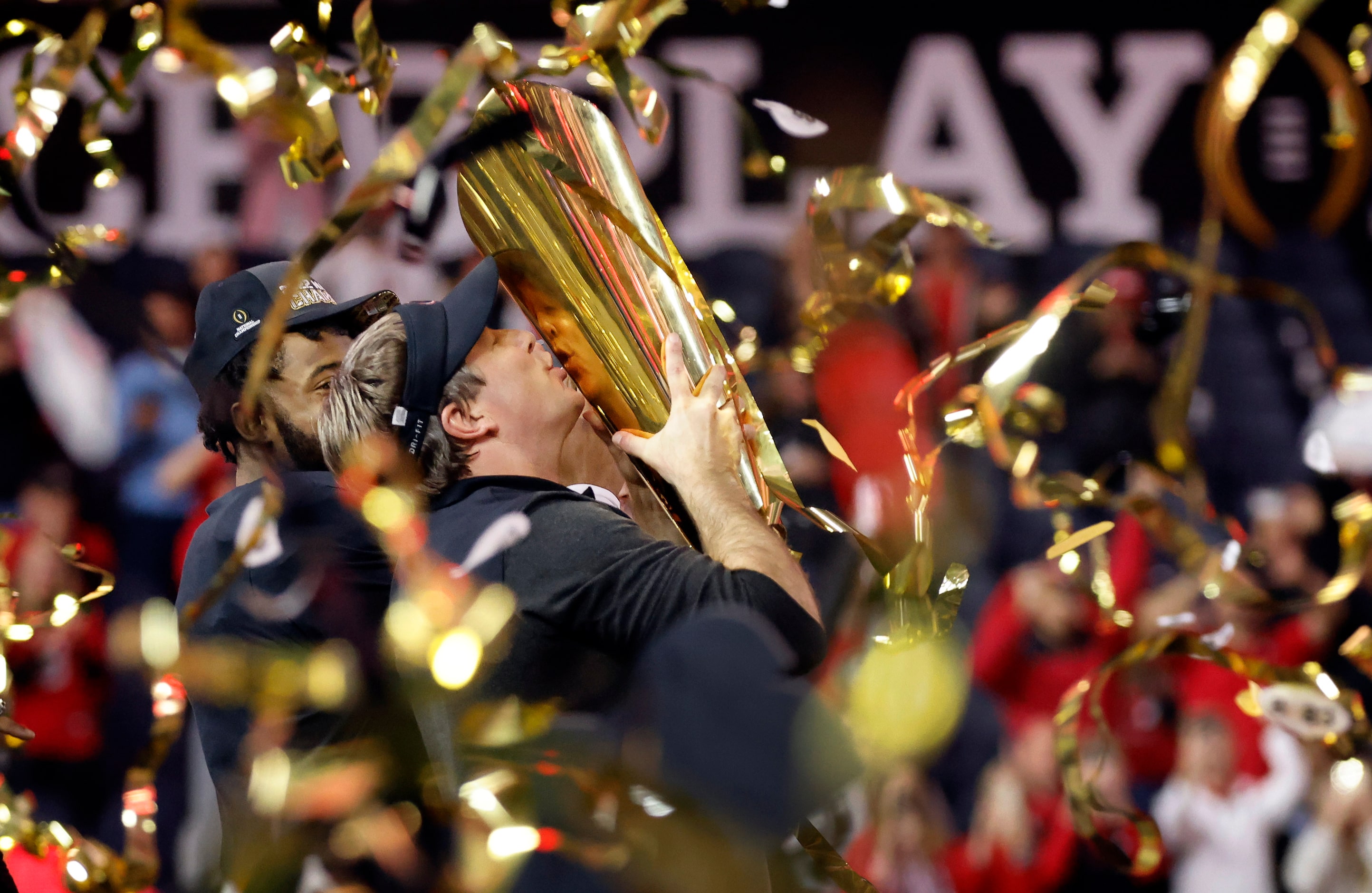 Under a hail of confetti, Georgia Bulldogs head coach Kirby Smart kisses the CFP National...