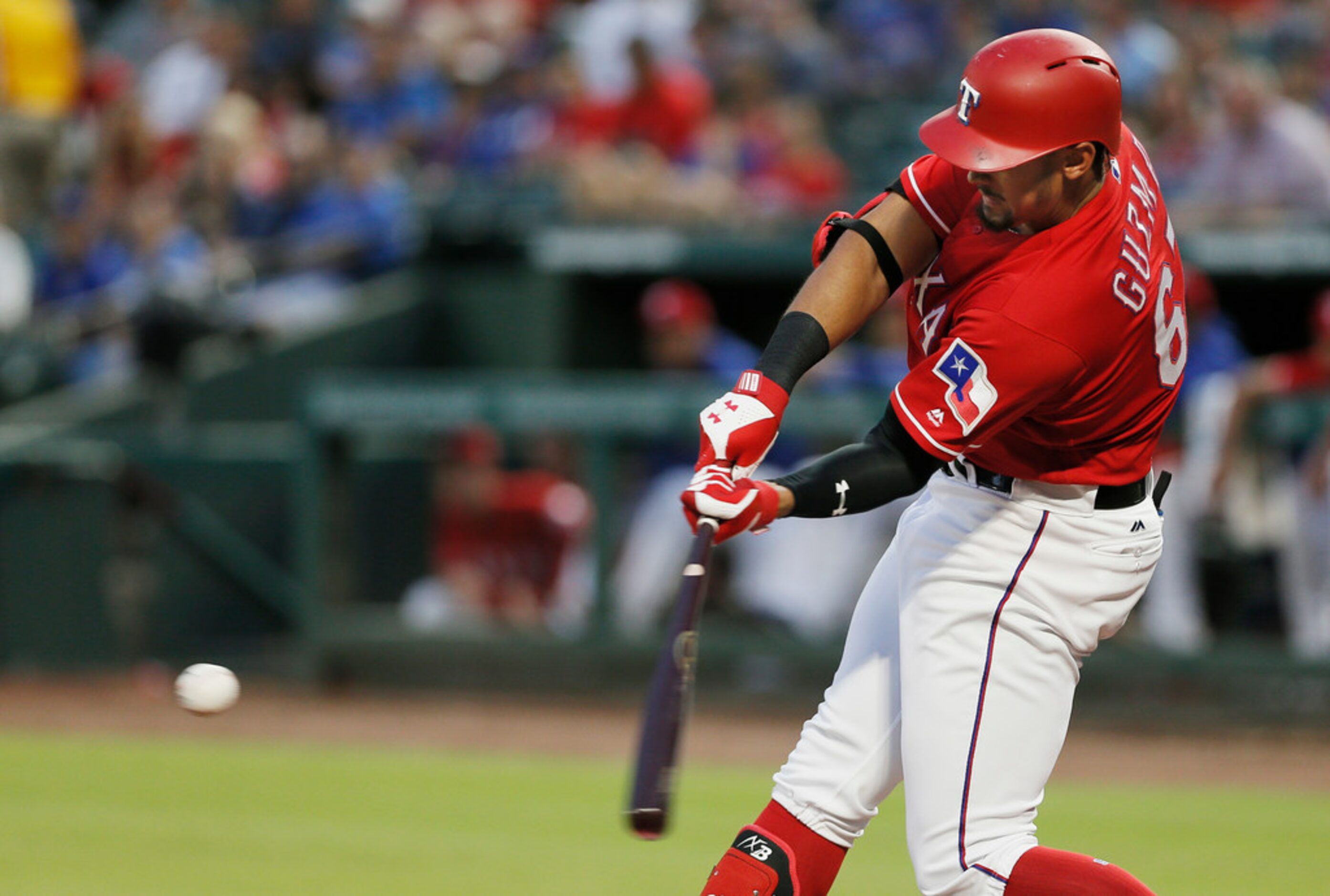 Texas Rangers' Ronald Guzman makes contact for a solo home run during the third inning of a...