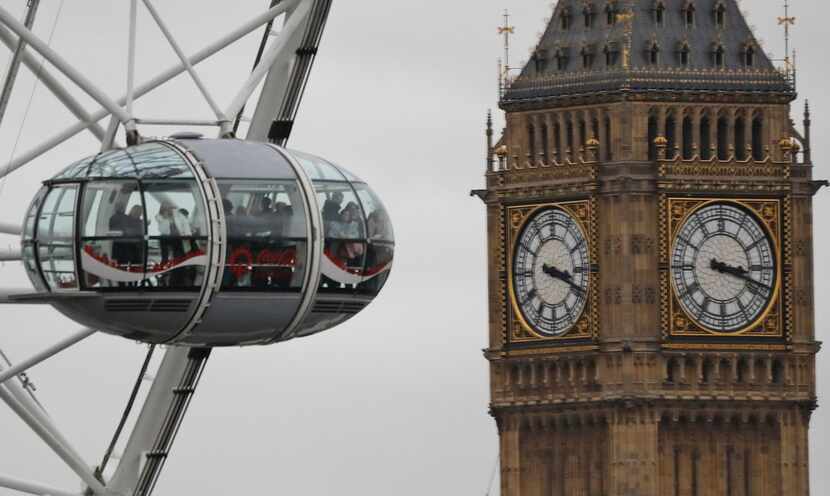 Bisitors enjoy the London Eye ride beside The Elizabeth Tower housing the Big Ben bell on a...