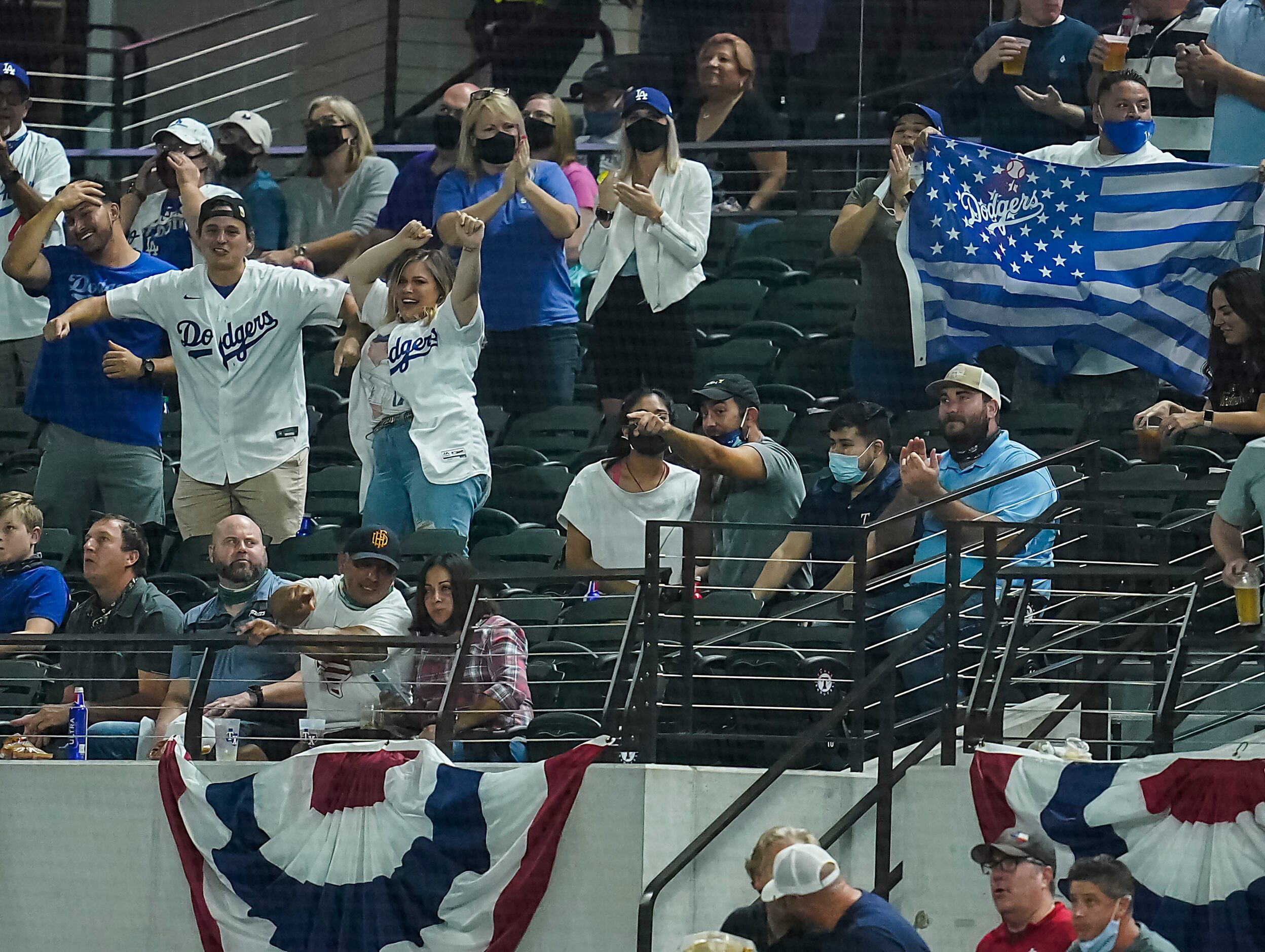 Los Angeles Dodgers fans celebrate after catcher Will Smith drove in two runs with a single...