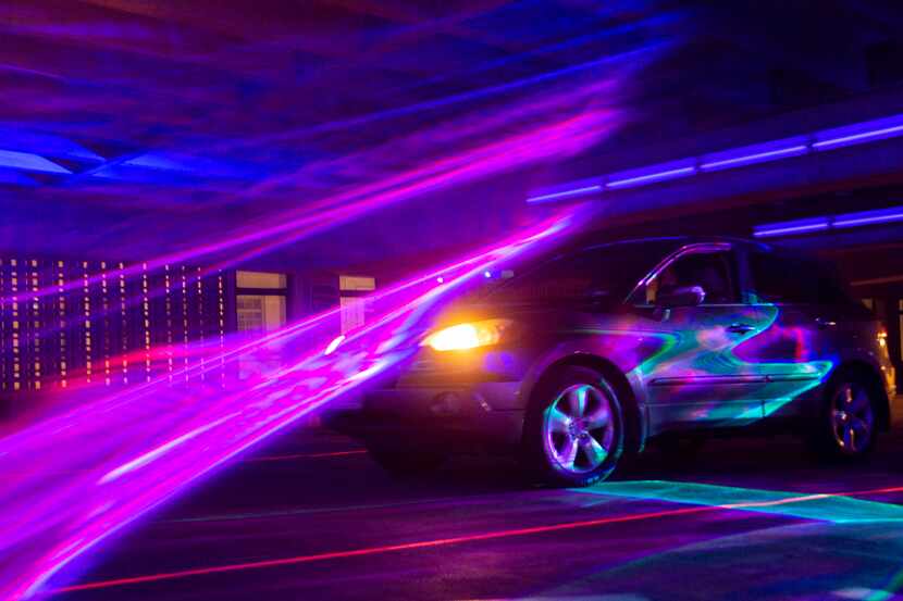 A car passes through Melanie Clemmons and Zak Loyd's "Laser Wash" in Aurora's Area 3 in the...