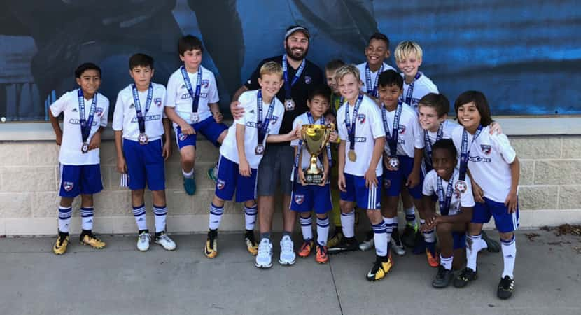 FC Dallas 07B Central Blue pose with the Bobby Rhine Invitational U11 Championship trophy.