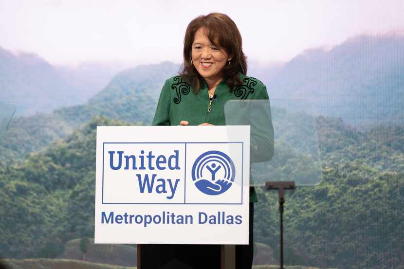 Anne Chow wears a green jacket and stands behind a podium, with a sign for United Way of...