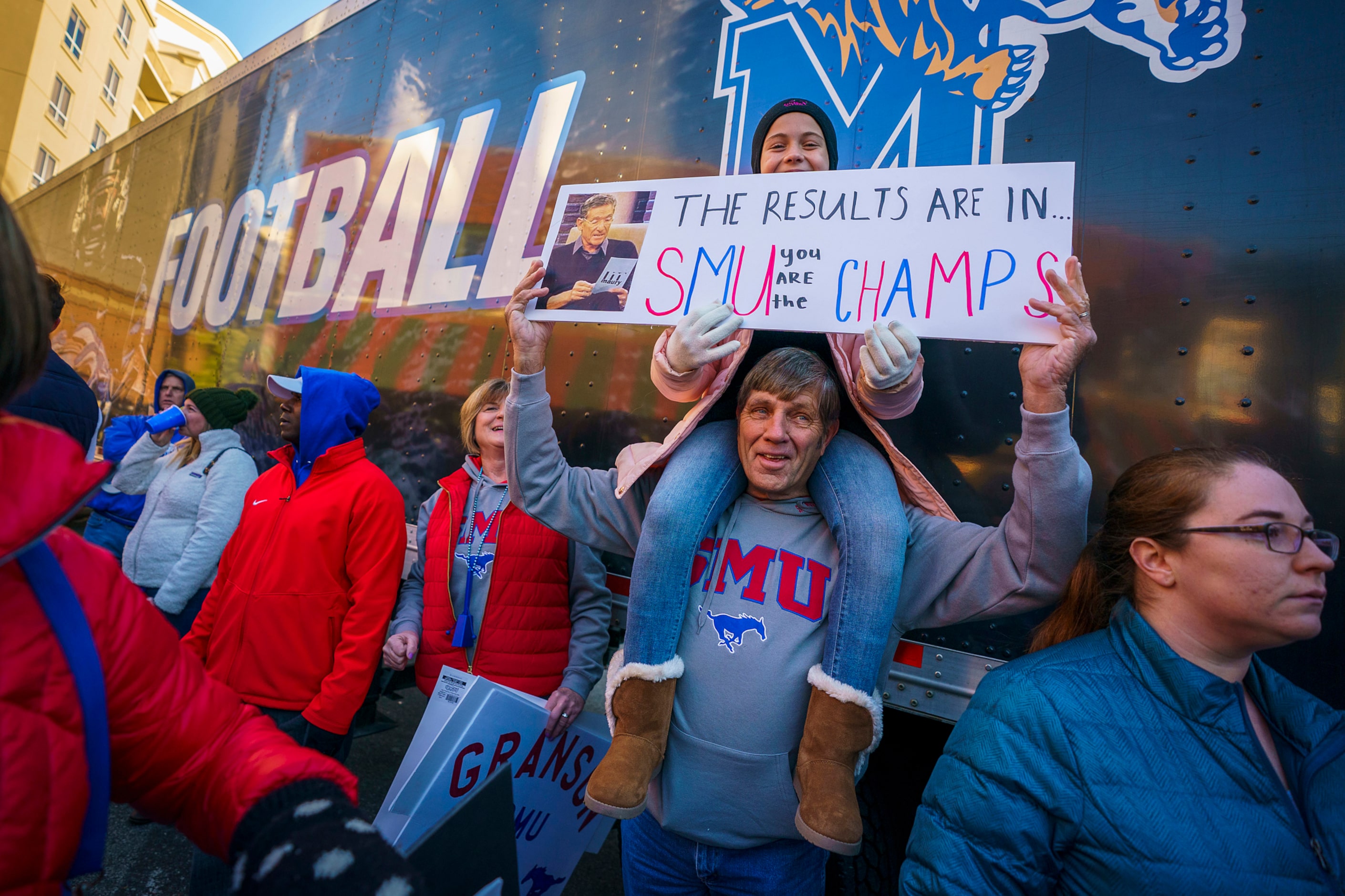 Ellie Granson, younger sister of SMU tight end Kylen Granson, holds a sign atop the...