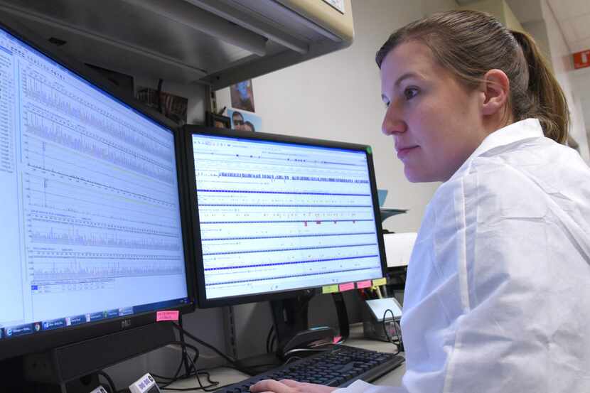 A medical technologist at UT Southwestern Medical Center analyzes results from a genetic...