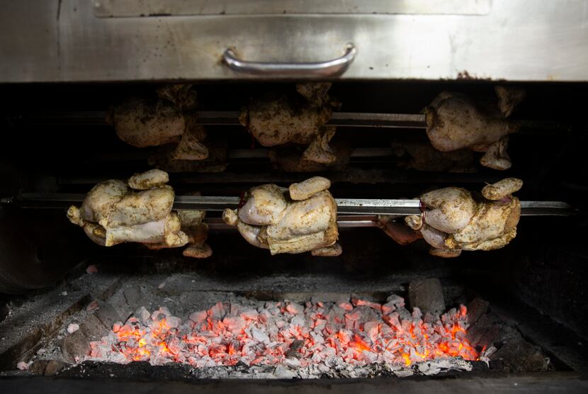 The pollo a la brasa (Peruvian roasted chicken) roasts in the oven at the Brasa Bar and...