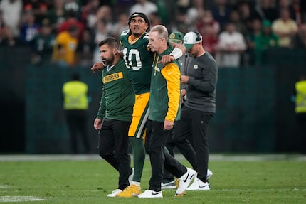 Green Bay Packers quarterback Jordan Love (10) is helped off the field after getting hurt...