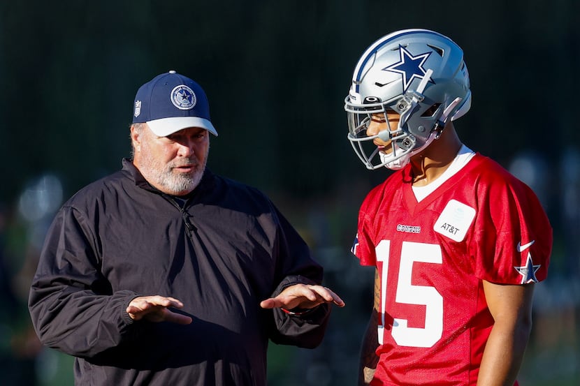 Dallas Cowboys head coach Mike McCarthy (center) talks with quarterback Trey Lance (15)...