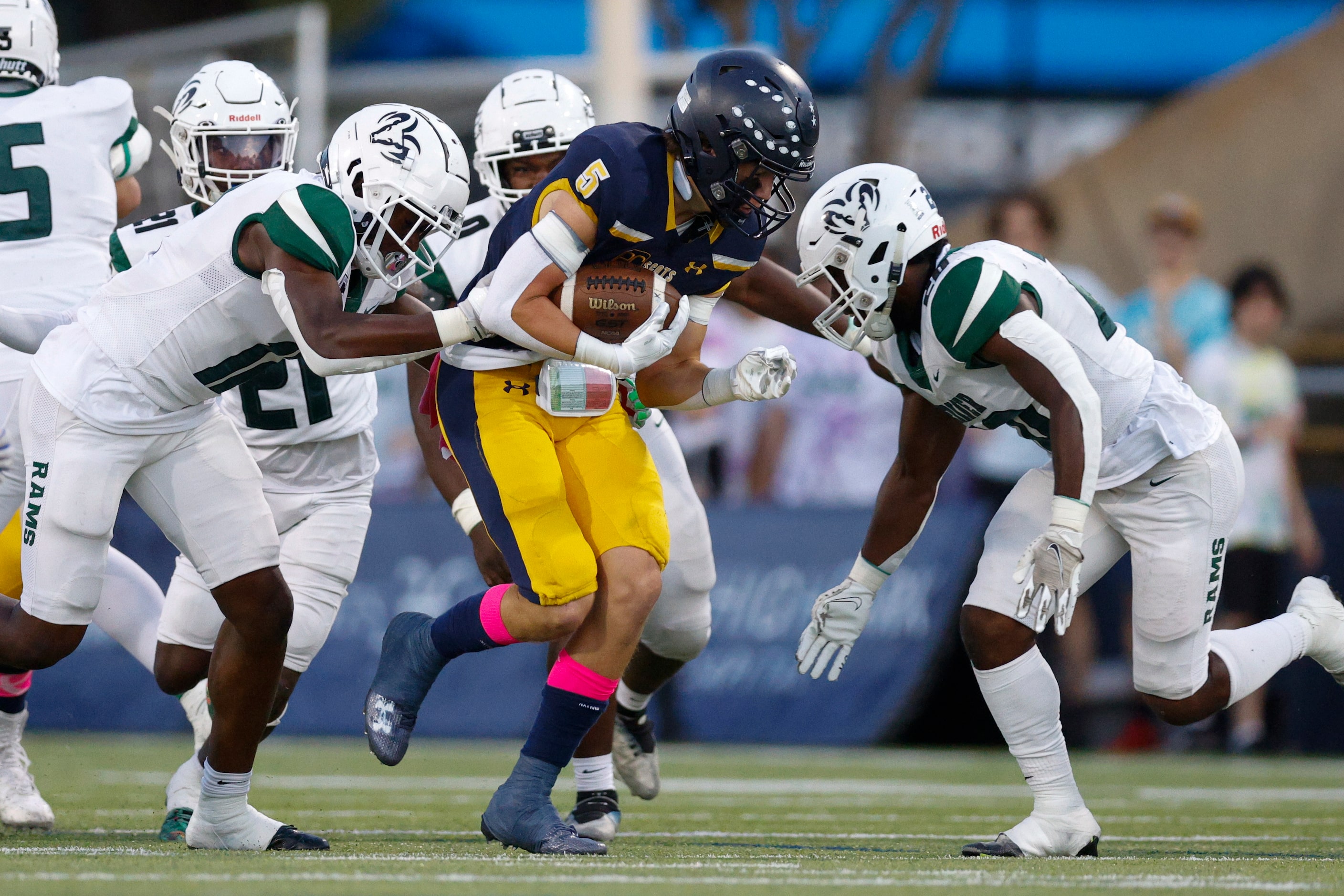 Highland Park running back Keller Holmes (5) is tackled by a trio of Richardson Berkner...