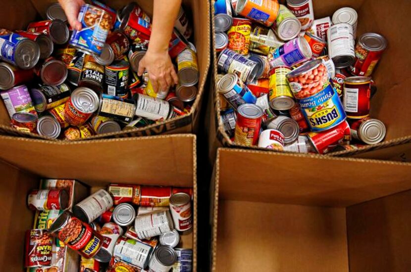 
Volunteers sort through canned foods at the food bank. More than 1,600 certified nonprofit...