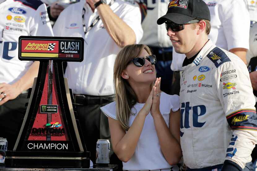 Brad Keselowski (right) and his wife, Paige White, celebrate in victory lane after he won...