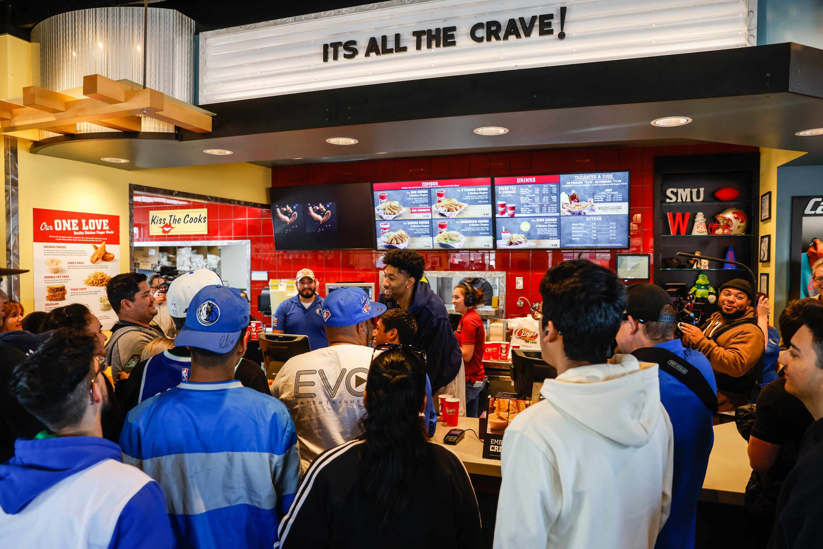 Mavericks player Christian Wood serves lunch at the Raising Cane’s in Dallas on Wednesday,...