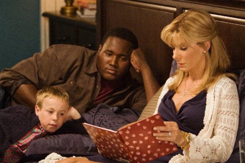 Jae Head as S.J. Tuohy, foreground left, Quinton Aaron as Michael Oher and Sandra Bullock as...