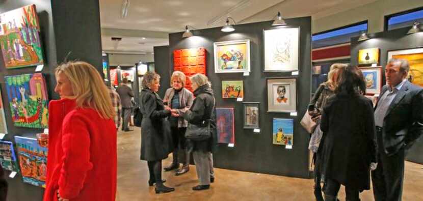 
Patrons check out the paintings as homeless artists display their work at the Stewpot's Pop...