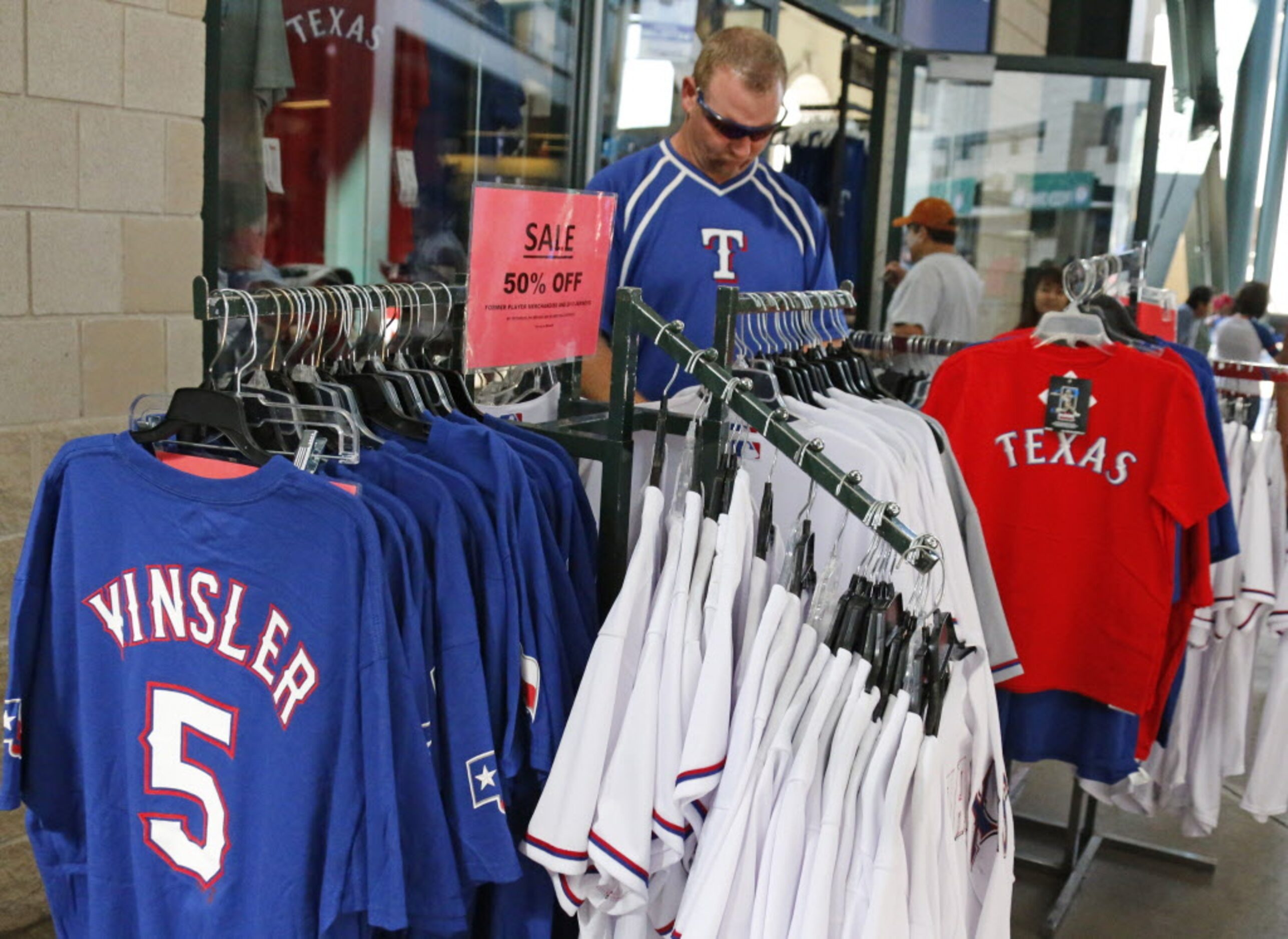 Scott Sexton of Arlington checks out the sale rack of Rangers jerseys during the Oakland...