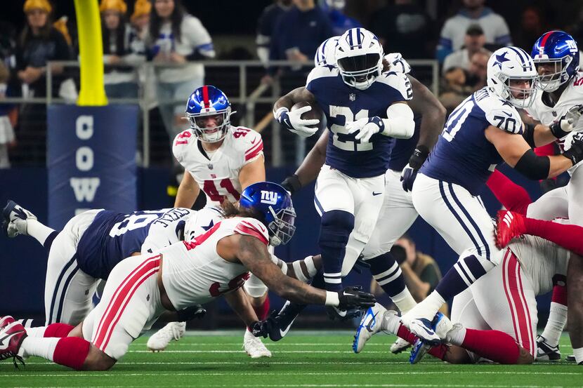 Dallas Cowboys running back Ezekiel Elliott (21) breaks through the New York Giants defends...