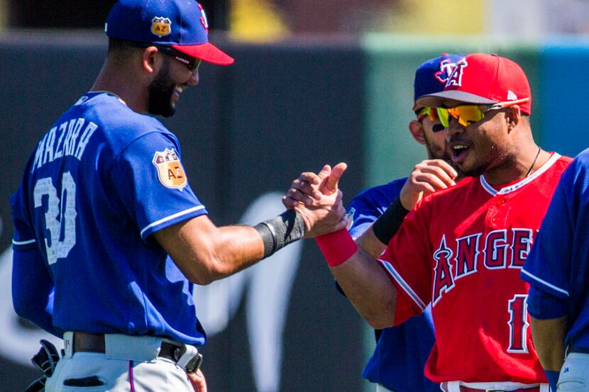 Texas Rangers right fielder Nomar Mazara (30) greets Los Angeles Angels third baseman Luis...