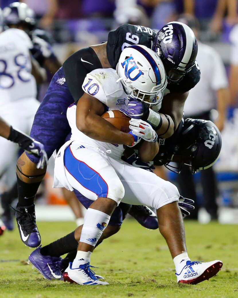 TCU Horned Frogs defensive tackle Ross Blacklock (90) tackles Kansas Jayhawks running back...