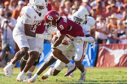 Oklahoma quarterback Michael Hawkins Jr. (9) fumbles as he is brought down by Texas...