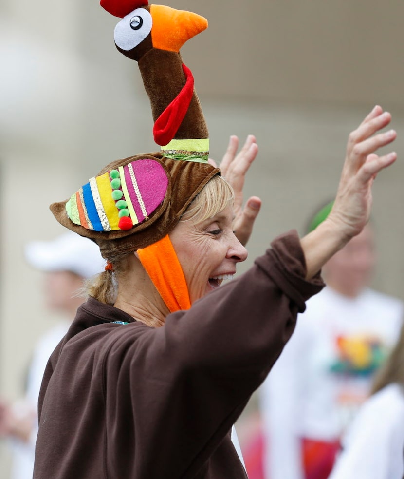 Jerri Hixson celebrates after crossing the 5K finish line at the Dallas YMCA Turkey Trot in...